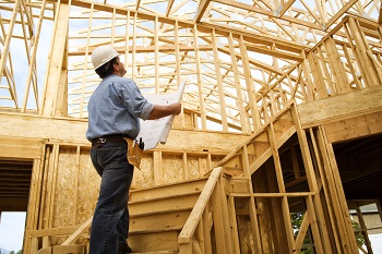 contractor inside of a home being built looking at plans