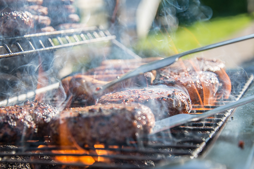 a close up of burgers being cooked on a grill