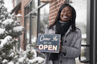 woman holding open sign for business